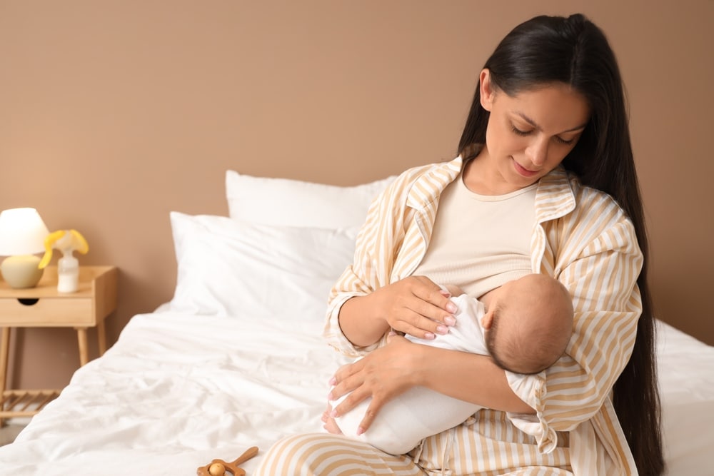 Mother,Breastfeeding,Her,Baby,In,Bedroom